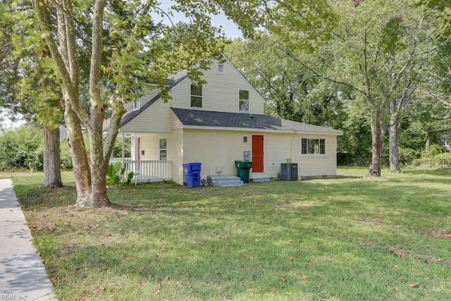 back of house featuring central AC unit and a yard