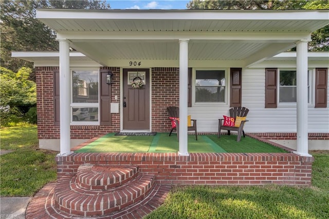 view of exterior entry featuring covered porch