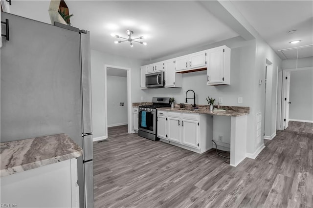 kitchen with white cabinets, stainless steel appliances, light hardwood / wood-style floors, and sink