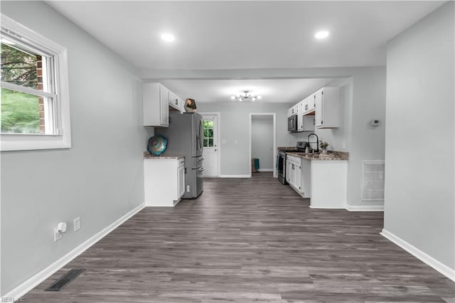 kitchen featuring stainless steel appliances, white cabinets, and dark wood-type flooring