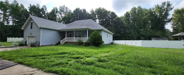 view of front of home with a garage, a front yard, and a porch