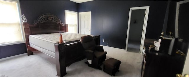 carpeted bedroom featuring a closet and multiple windows