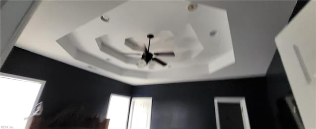 room details featuring ceiling fan and a raised ceiling