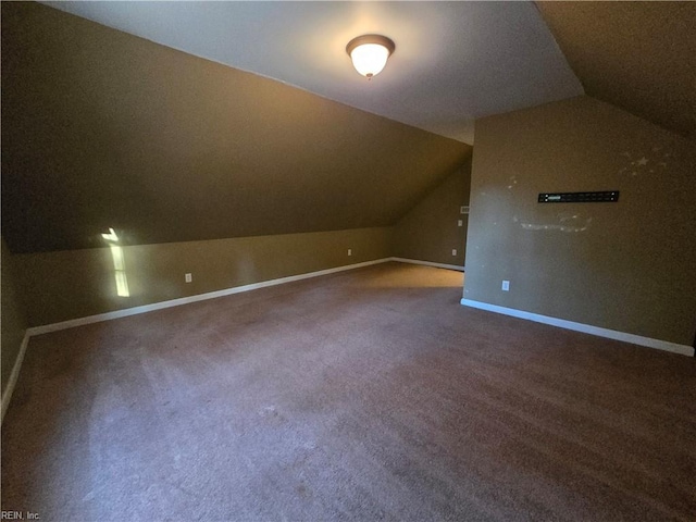 additional living space with carpet flooring and vaulted ceiling