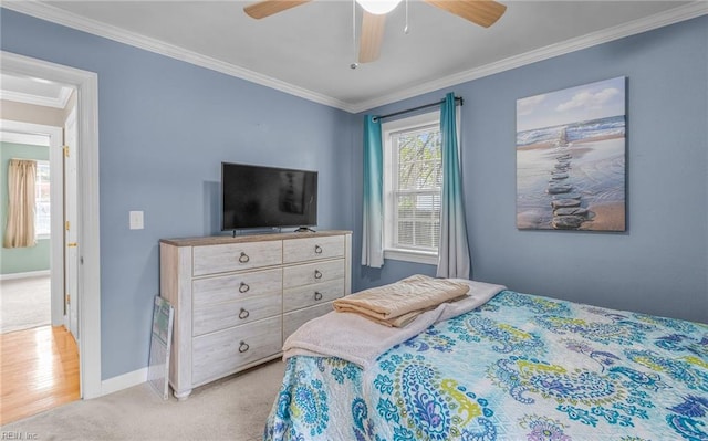 carpeted bedroom with ceiling fan and crown molding