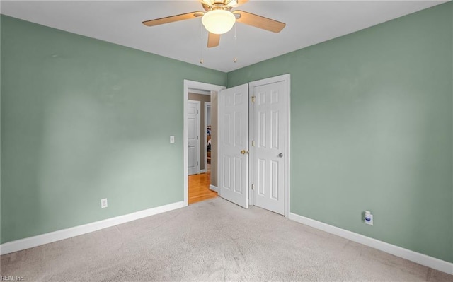 unfurnished bedroom featuring light colored carpet and ceiling fan