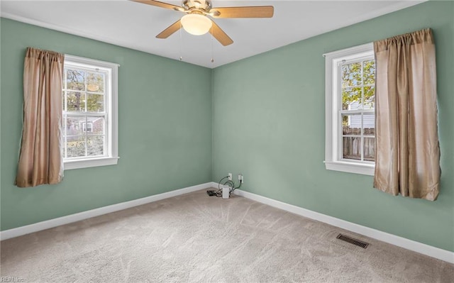 carpeted empty room featuring a healthy amount of sunlight and ceiling fan