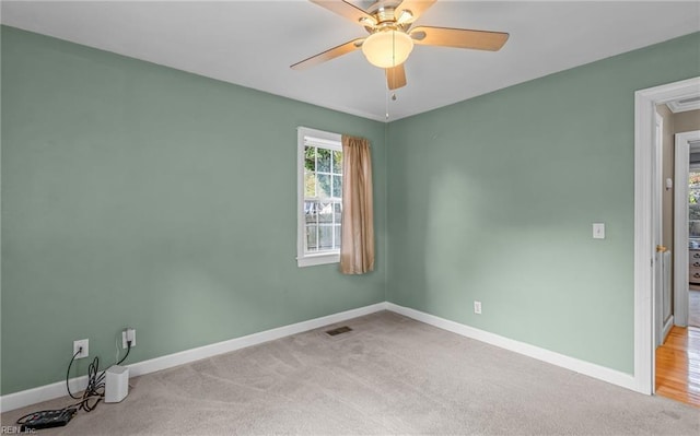 empty room featuring ceiling fan and light carpet