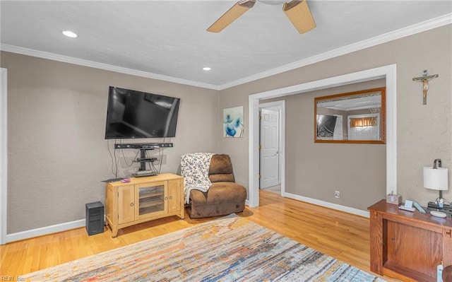 living area featuring ornamental molding, light hardwood / wood-style flooring, and ceiling fan