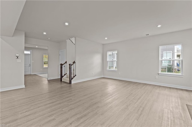 unfurnished living room with a healthy amount of sunlight and light wood-type flooring