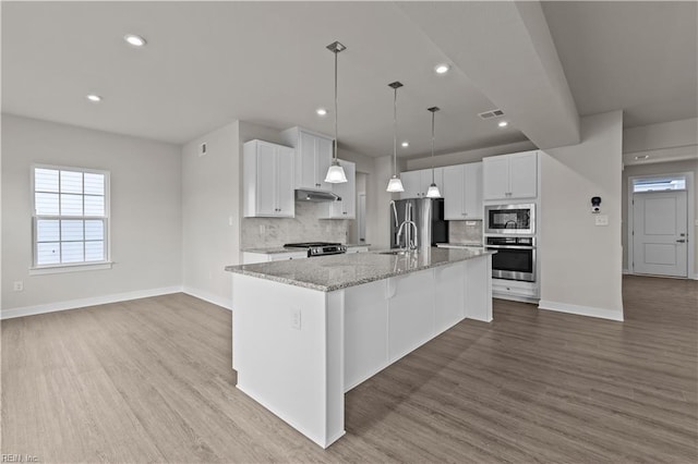 kitchen featuring white cabinetry, light hardwood / wood-style flooring, a kitchen island with sink, and appliances with stainless steel finishes