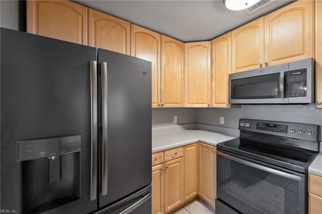 kitchen with stainless steel appliances, light tile patterned floors, and light brown cabinets