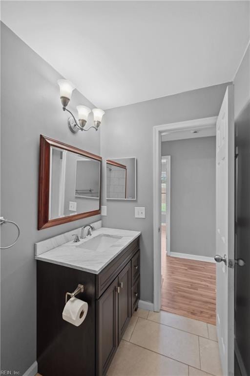 bathroom featuring hardwood / wood-style flooring, a chandelier, and vanity