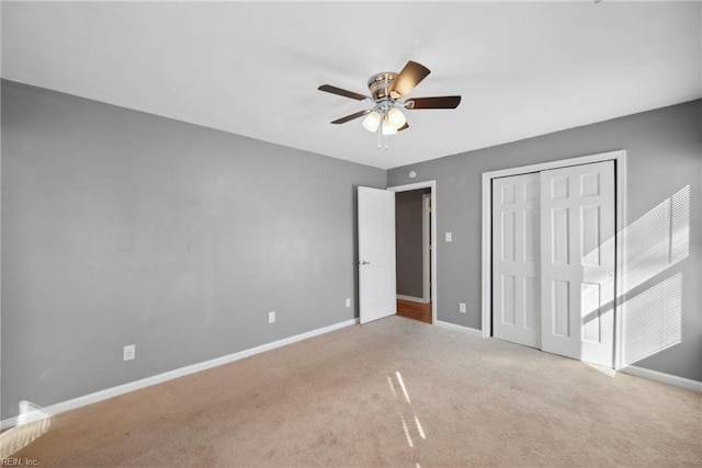 unfurnished bedroom with light carpet, ceiling fan, and a closet