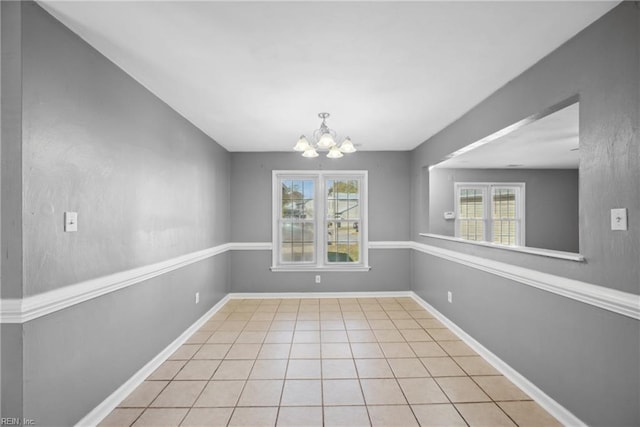 unfurnished dining area featuring a chandelier, a wealth of natural light, and light tile patterned floors