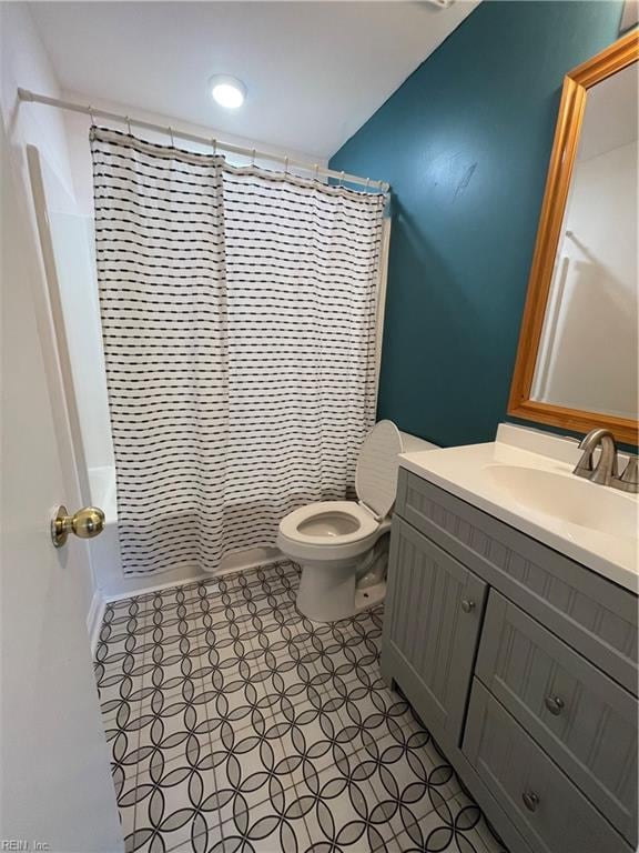 bathroom with walk in shower, vanity, and toilet