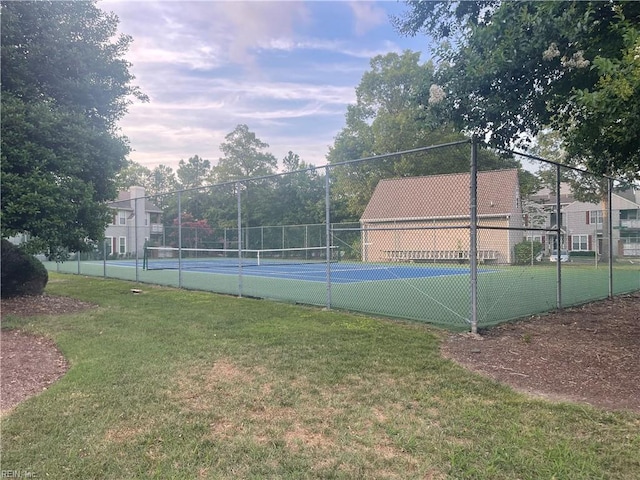 view of tennis court featuring a yard