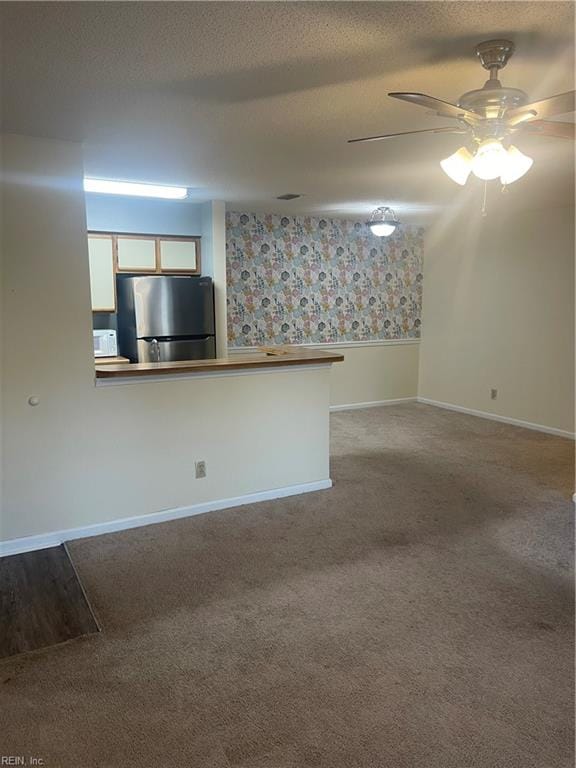 interior space with carpet, a textured ceiling, and ceiling fan