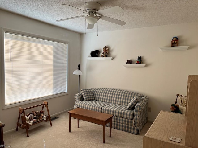 sitting room featuring a textured ceiling, light carpet, and ceiling fan