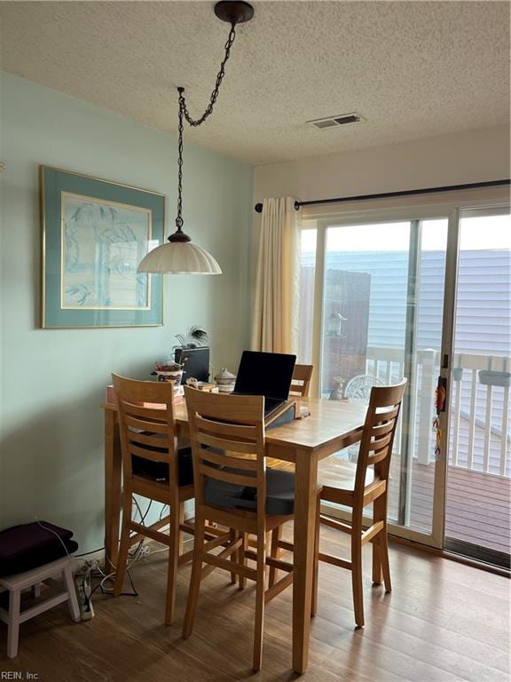 dining area featuring hardwood / wood-style floors and a textured ceiling