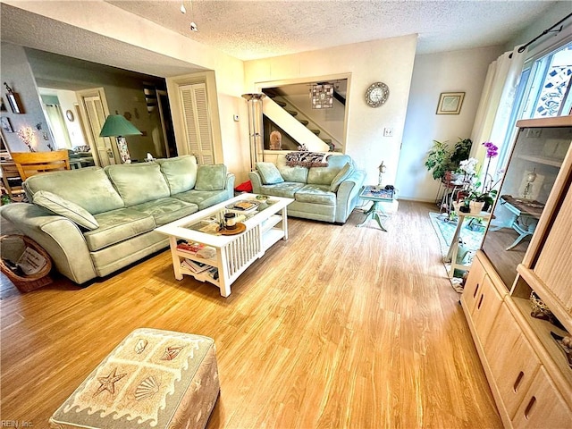 living room with light wood-type flooring and a textured ceiling