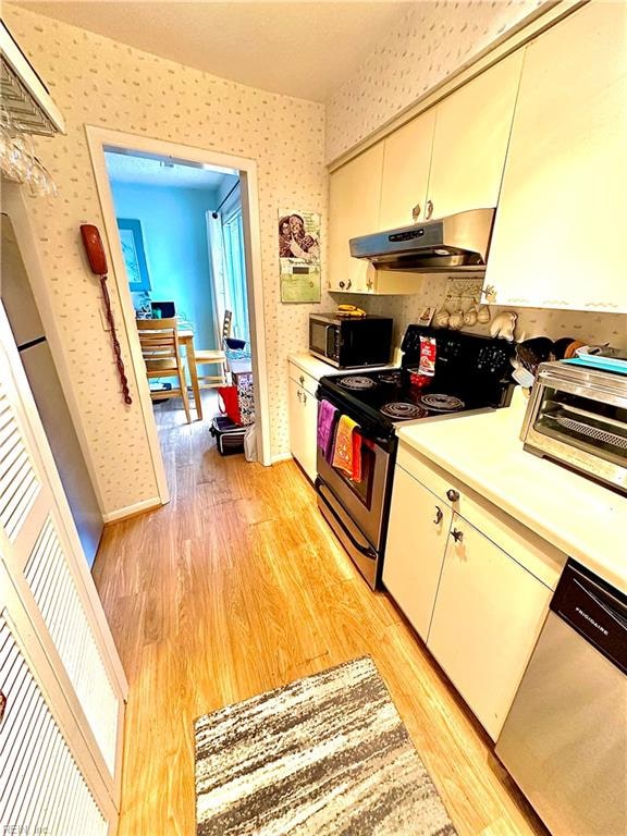 kitchen with appliances with stainless steel finishes and light hardwood / wood-style flooring