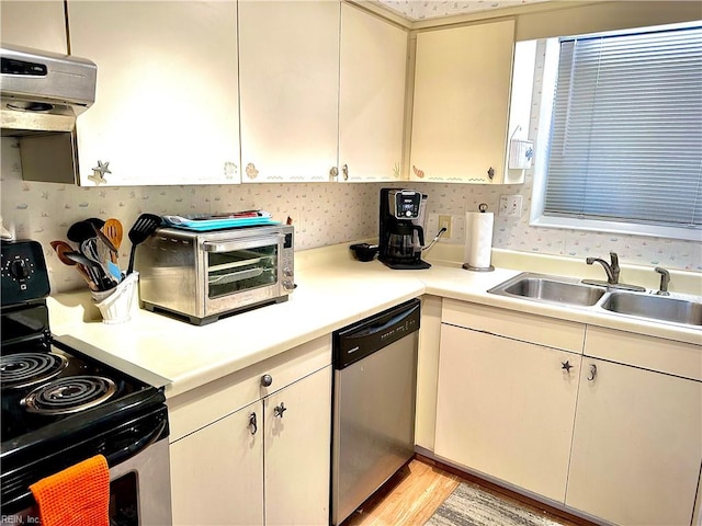 kitchen featuring stainless steel appliances, sink, light wood-type flooring, and exhaust hood