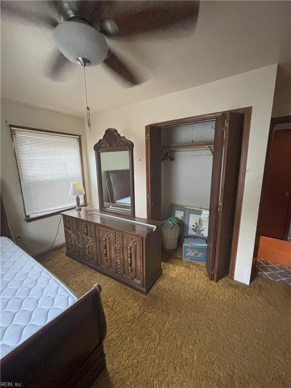 carpeted bedroom with ceiling fan and a closet