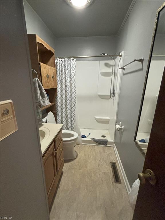 bathroom featuring toilet, vanity, a shower with shower curtain, and hardwood / wood-style flooring