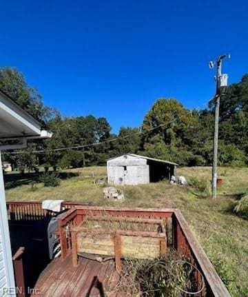 view of yard featuring a deck and an outbuilding