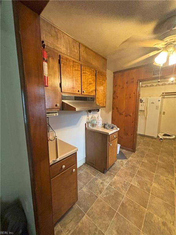 kitchen featuring ceiling fan, a textured ceiling, and white refrigerator