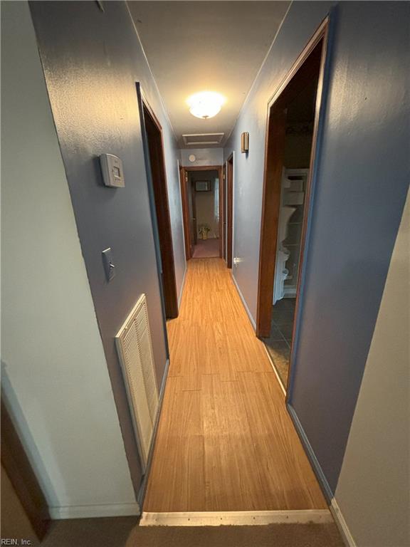 hallway with light hardwood / wood-style floors