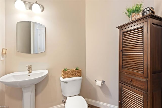 bathroom with toilet and baseboards