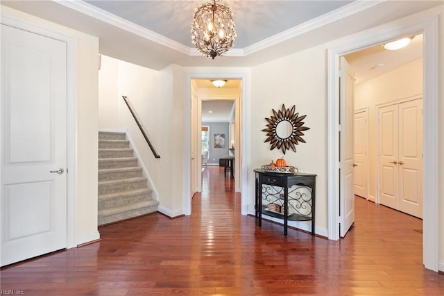 hallway featuring a notable chandelier, stairway, dark wood finished floors, and baseboards