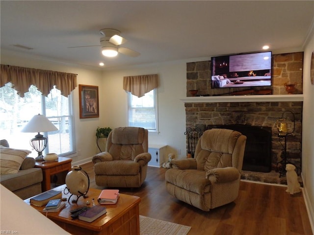 living room featuring ornamental molding, a fireplace, wood-type flooring, and ceiling fan