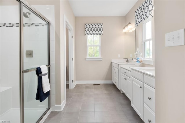 bathroom with a wealth of natural light, a shower with shower door, vanity, and tile patterned flooring