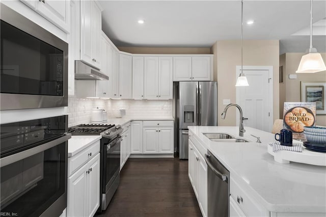 kitchen featuring stainless steel appliances, decorative light fixtures, dark hardwood / wood-style flooring, sink, and white cabinets