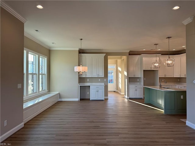 kitchen featuring crown molding, white cabinetry, dark hardwood / wood-style floors, pendant lighting, and sink