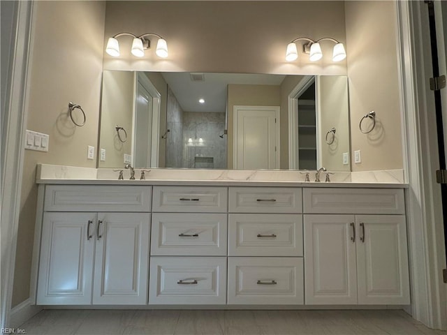 bathroom with vanity and a tile shower