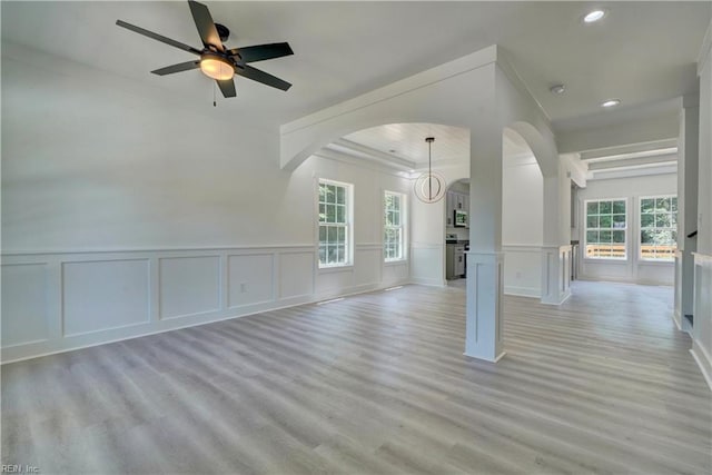 unfurnished living room featuring ornamental molding, light hardwood / wood-style floors, and ceiling fan