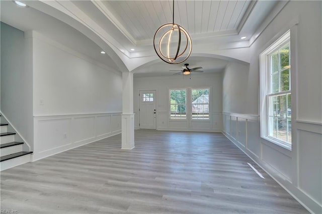 interior space with hardwood / wood-style floors, a wealth of natural light, a raised ceiling, and ornamental molding