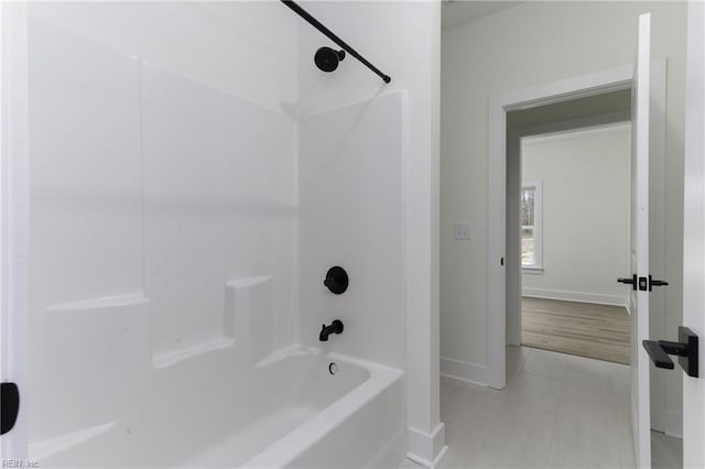 bathroom featuring washtub / shower combination and hardwood / wood-style flooring