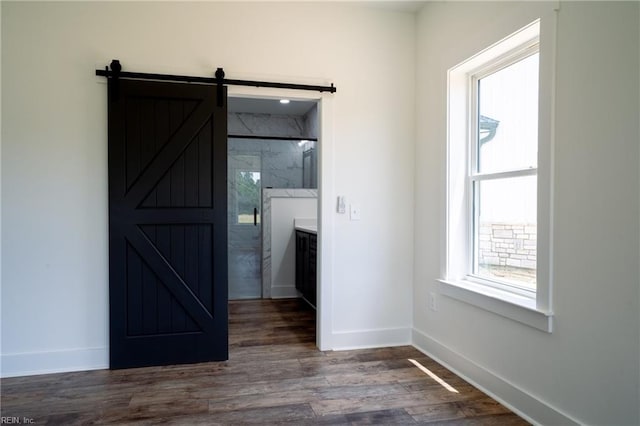 interior space featuring a barn door and dark hardwood / wood-style flooring