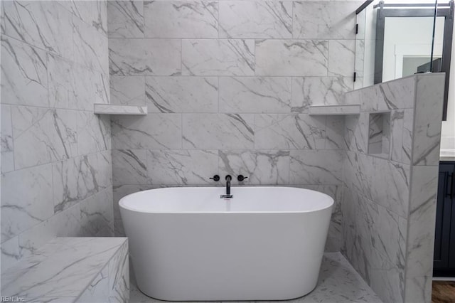 bathroom featuring tile walls, a washtub, and vanity