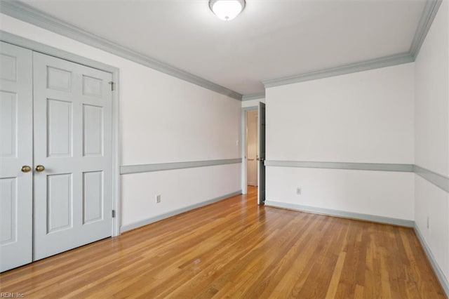 unfurnished room with light wood-type flooring and crown molding