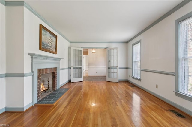 unfurnished living room with hardwood / wood-style floors, plenty of natural light, and french doors