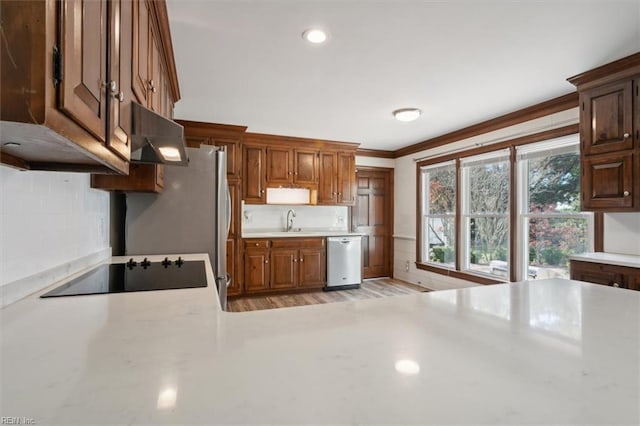 kitchen with black electric cooktop, sink, ornamental molding, stainless steel dishwasher, and light wood-type flooring