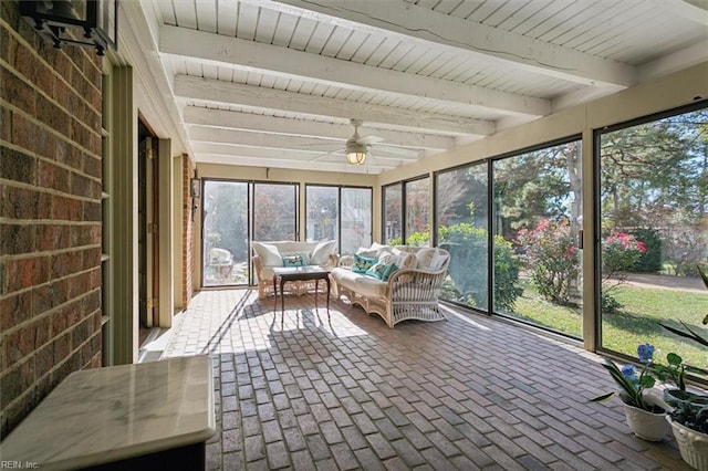 unfurnished sunroom featuring ceiling fan and beam ceiling