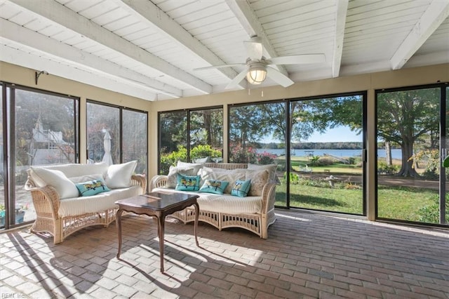 sunroom with ceiling fan, a wealth of natural light, beamed ceiling, and a water view