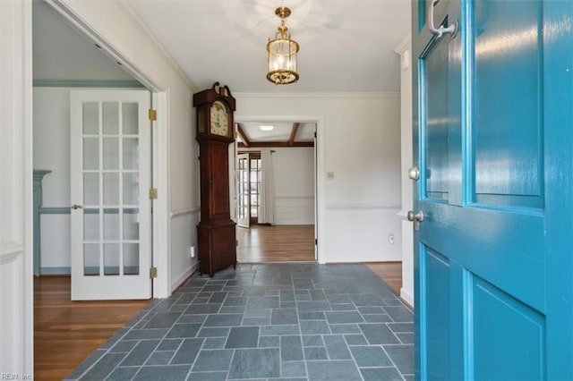 entryway featuring dark hardwood / wood-style flooring, a notable chandelier, and crown molding